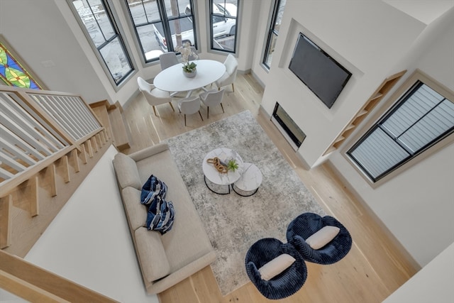 living room featuring a towering ceiling and hardwood / wood-style flooring