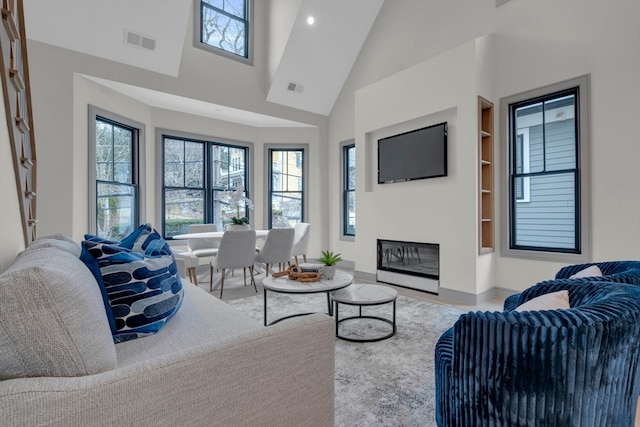 living room with high vaulted ceiling and built in features