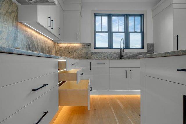 kitchen featuring white cabinets, light hardwood / wood-style flooring, and sink