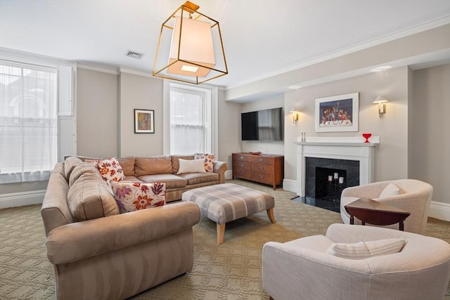 carpeted living area featuring plenty of natural light, crown molding, baseboards, and visible vents