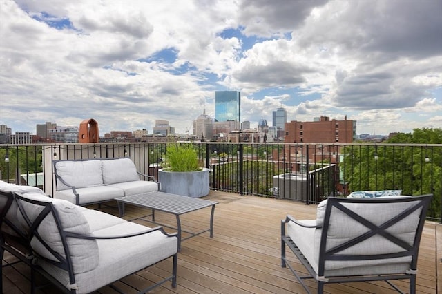 wooden terrace featuring an outdoor hangout area and a city view