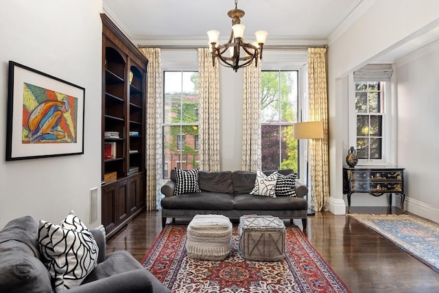 living room featuring dark wood-type flooring, ornamental molding, baseboards, and an inviting chandelier