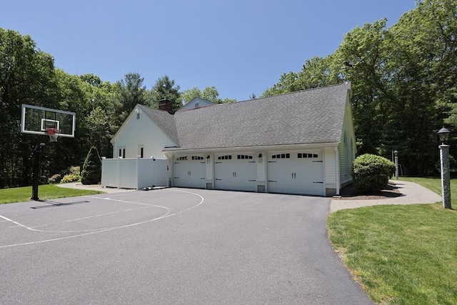 8 Mercer Ln, Franklin, MA 02038 - exterior space with a front lawn, asphalt driveway, a garage, a chimney, and roof with shingles