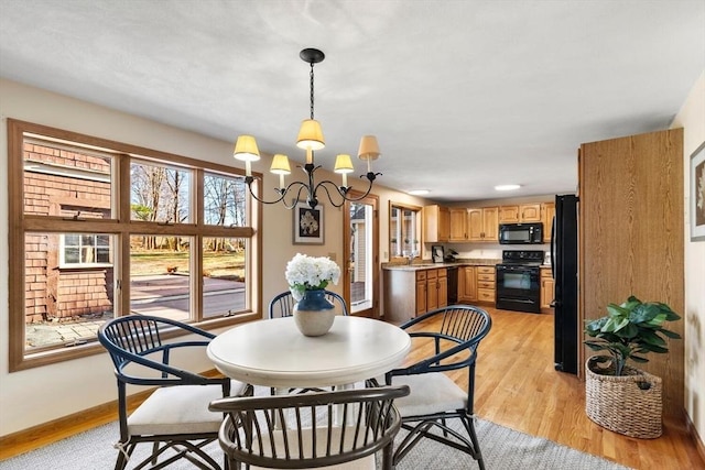 dining space featuring a notable chandelier, light wood-type flooring, and sink