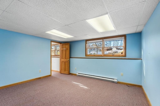 unfurnished room featuring carpet, a paneled ceiling, and baseboard heating