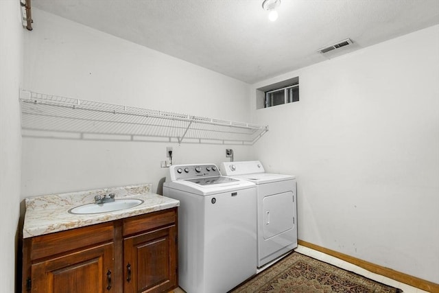 laundry area with separate washer and dryer and sink