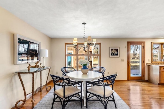 dining area with light hardwood / wood-style flooring and a chandelier