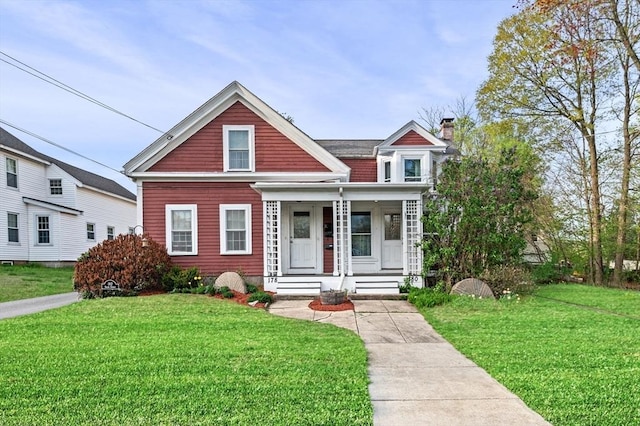 view of front facade with a porch, a chimney, and a front yard