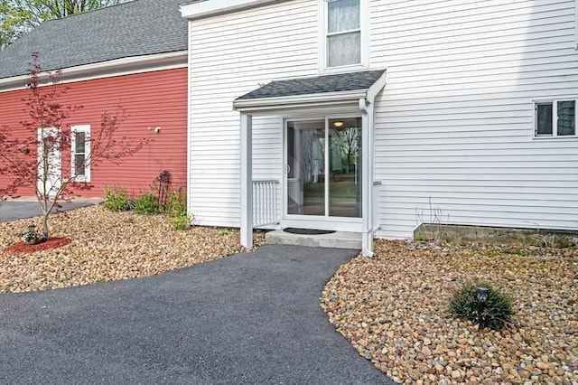 property entrance featuring a shingled roof