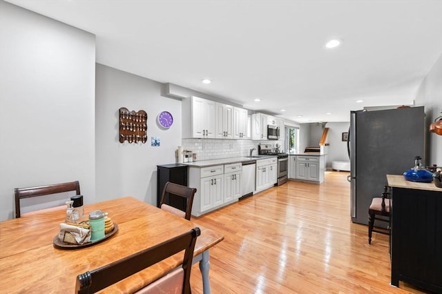 dining room with recessed lighting and light wood-type flooring