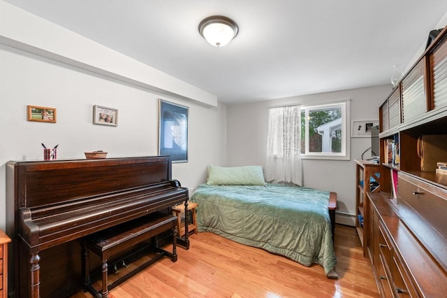 bedroom featuring baseboard heating and light wood-style flooring