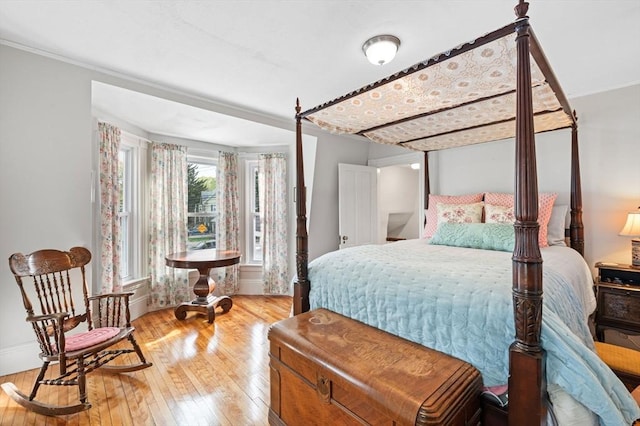 bedroom with wood-type flooring, baseboards, and crown molding