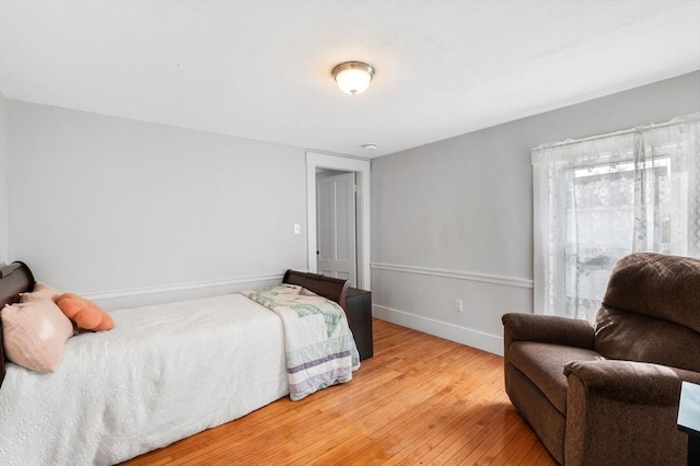 bedroom with baseboards and hardwood / wood-style flooring