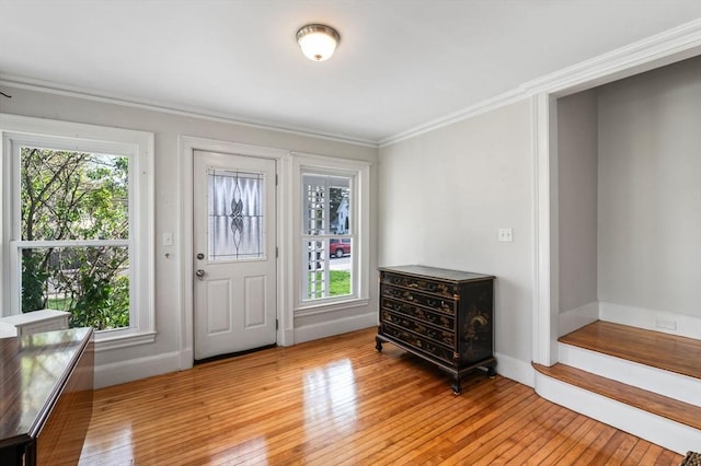 foyer with crown molding, stairway, baseboards, and light wood finished floors