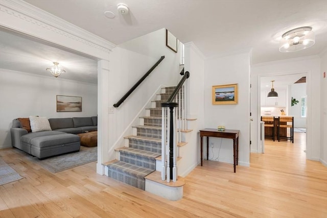 stairs featuring baseboards, ornamental molding, and wood finished floors