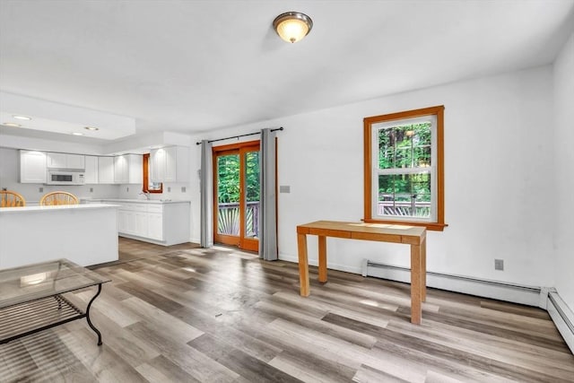 kitchen featuring light hardwood / wood-style floors, sink, white cabinets, and a healthy amount of sunlight