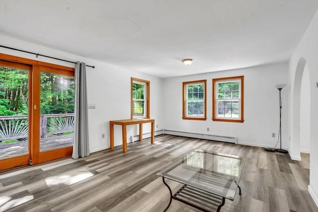 spare room featuring a baseboard radiator and light hardwood / wood-style floors