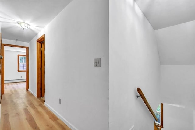 hallway with baseboard heating and light hardwood / wood-style flooring