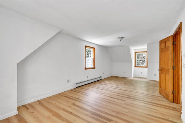 bonus room featuring baseboard heating, plenty of natural light, light hardwood / wood-style flooring, and vaulted ceiling