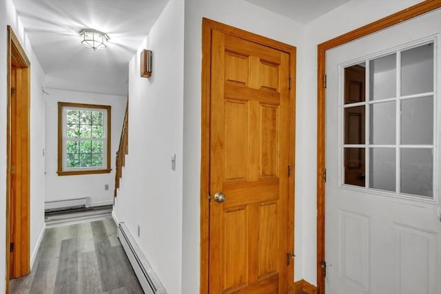 corridor featuring a baseboard heating unit and hardwood / wood-style floors