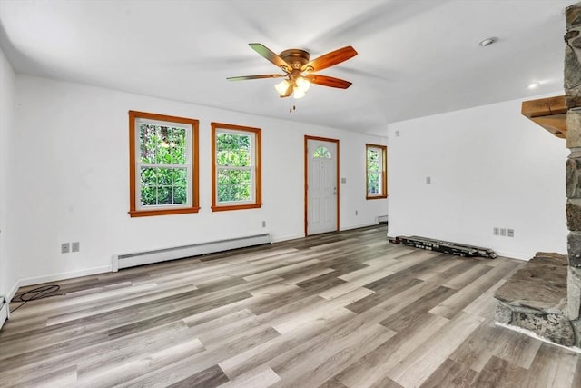 unfurnished living room with baseboard heating, light hardwood / wood-style floors, and ceiling fan