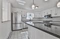 kitchen with dark countertops, decorative light fixtures, and white cabinetry