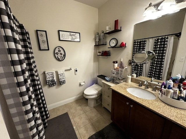 bathroom featuring baseboards, vanity, toilet, and tile patterned floors