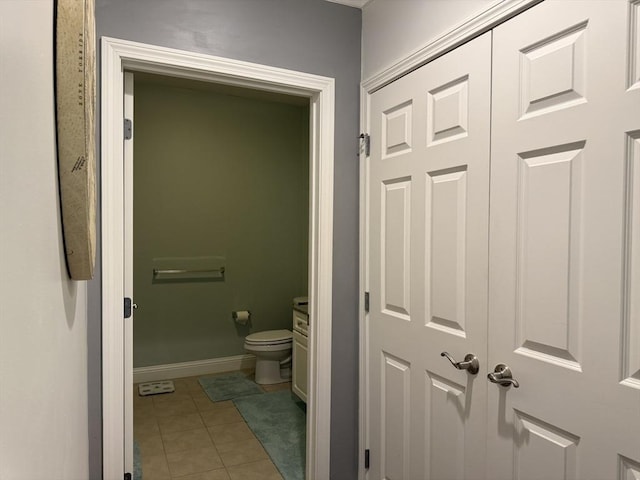 bathroom with toilet, baseboards, and tile patterned floors