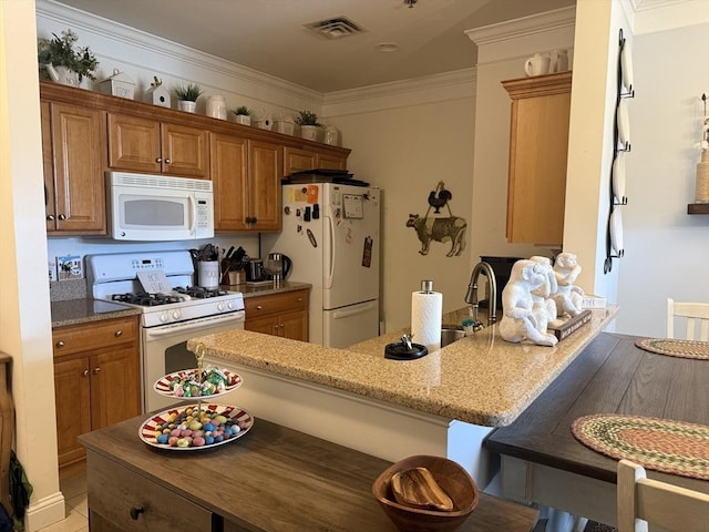 kitchen featuring ornamental molding, white appliances, brown cabinetry, and light stone countertops