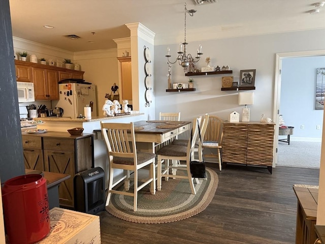 dining area with visible vents, dark wood finished floors, crown molding, and a chandelier