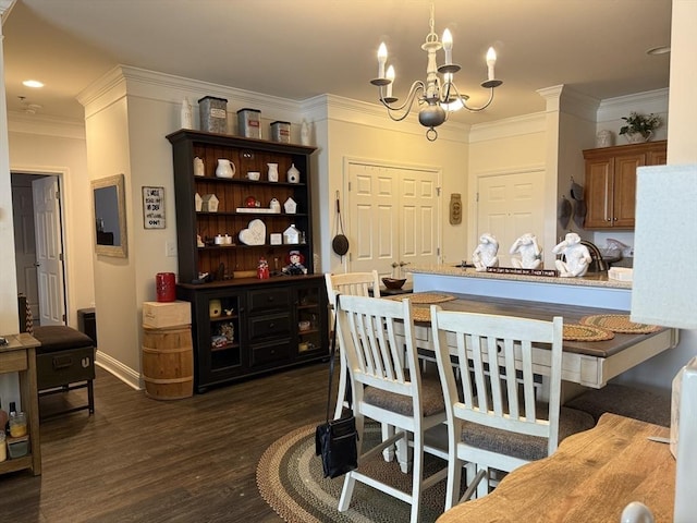 dining room with baseboards, ornamental molding, dark wood finished floors, and a notable chandelier