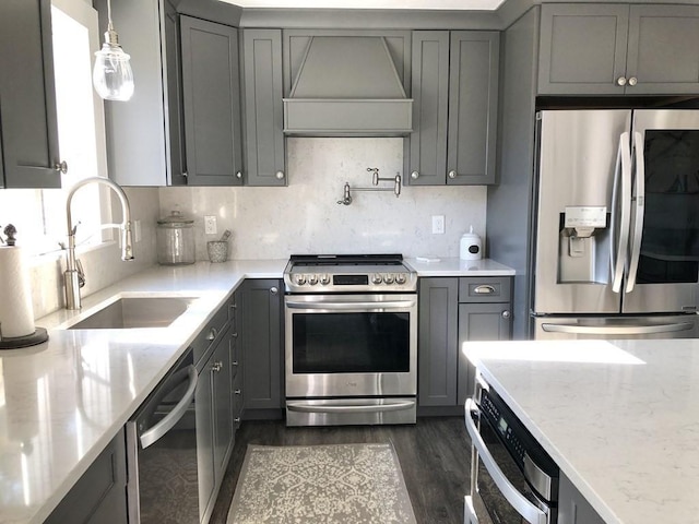 kitchen featuring gray cabinets, custom exhaust hood, a sink, and stainless steel appliances