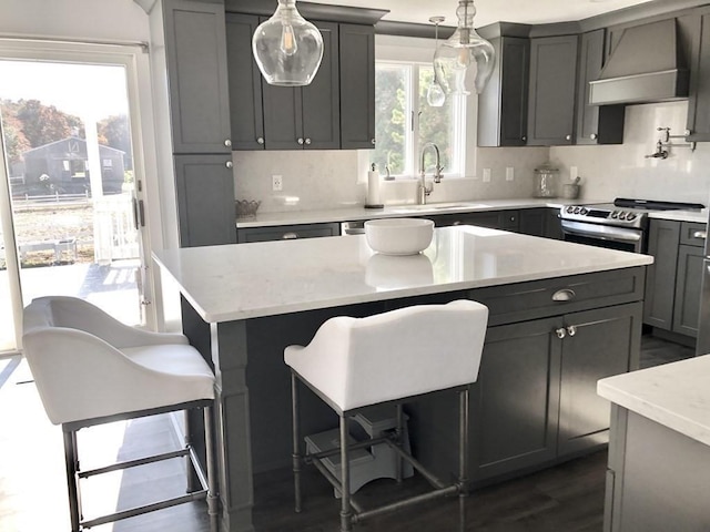 kitchen featuring gray cabinetry, custom exhaust hood, and a sink