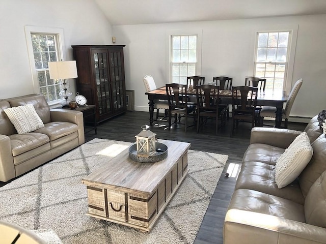 living room with baseboards, vaulted ceiling, and dark wood-style floors