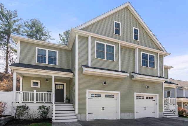 view of front of property with a porch, aphalt driveway, stairway, and a garage