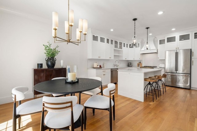 dining room with recessed lighting, an inviting chandelier, and light wood-style flooring