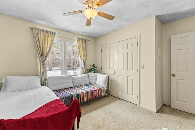 bedroom featuring light colored carpet, a closet, and ceiling fan