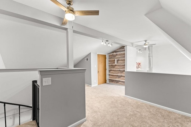 bonus room with vaulted ceiling, light colored carpet, and wooden walls