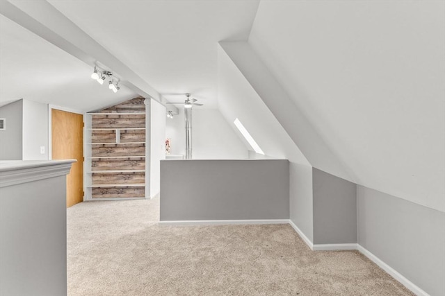 bonus room with ceiling fan, vaulted ceiling, and light carpet