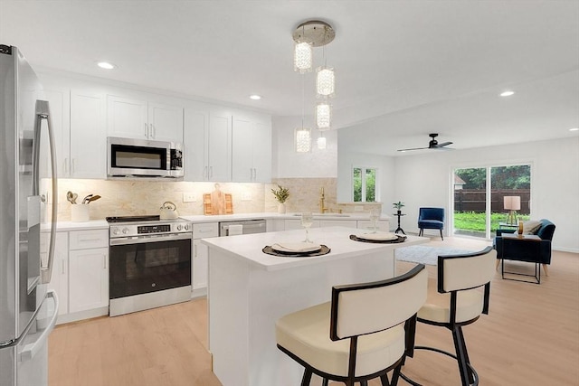 831 Morgan Rd, West Springfield, MA 01089 - kitchen with appliances with stainless steel finishes, light wood-style floors, decorative backsplash, white cabinetry, and light countertops