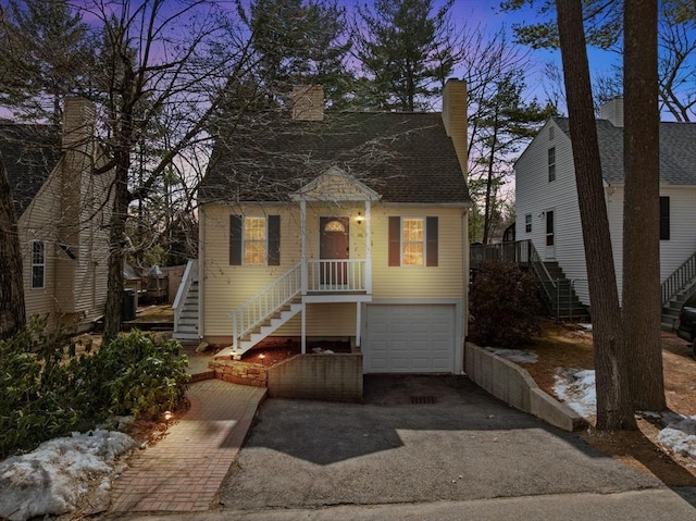 view of front of property featuring stairway, driveway, a chimney, and a garage