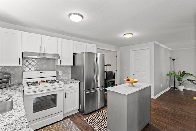 kitchen with white range with gas cooktop, under cabinet range hood, white cabinetry, freestanding refrigerator, and dark wood-style flooring