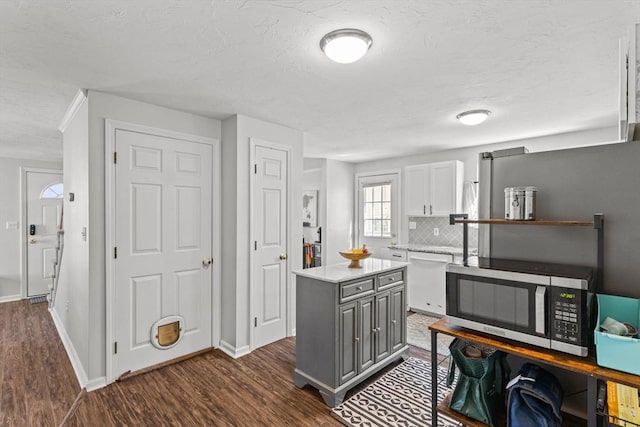 kitchen featuring gray cabinetry, stainless steel microwave, white cabinetry, light countertops, and dishwasher