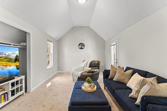 living area featuring lofted ceiling, baseboards, and light carpet