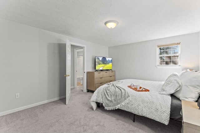 bedroom featuring light colored carpet, baseboards, and a textured ceiling