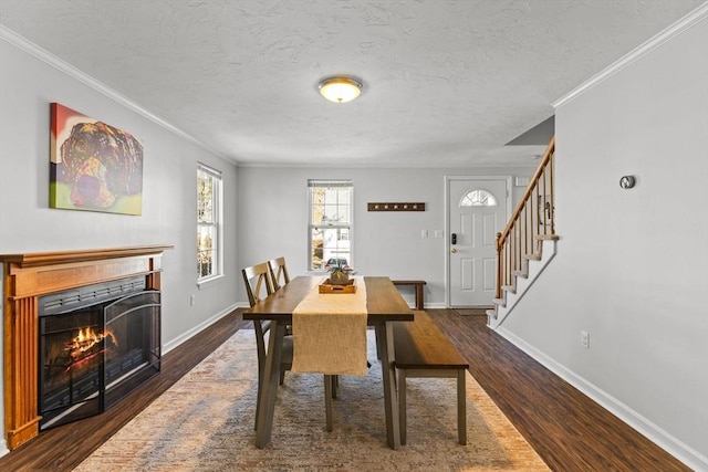 dining area featuring dark wood-style floors, baseboards, stairs, and a lit fireplace