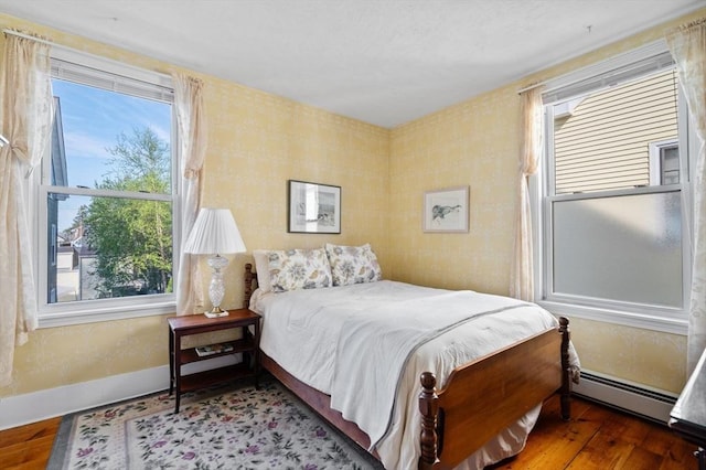 48 Northey St Unit 48, Salem, MA 01970 - bedroom featuring a baseboard radiator, wood finished floors, multiple windows, and wallpapered walls