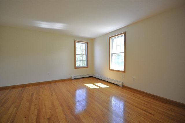 unfurnished room with baseboards, baseboard heating, and wood finished floors
