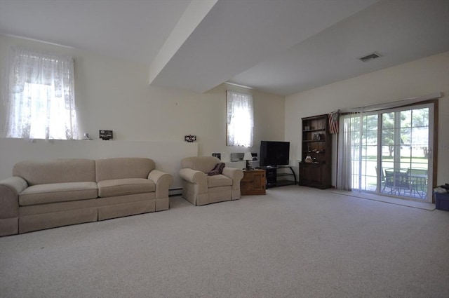 carpeted living room with baseboard heating, visible vents, and a healthy amount of sunlight
