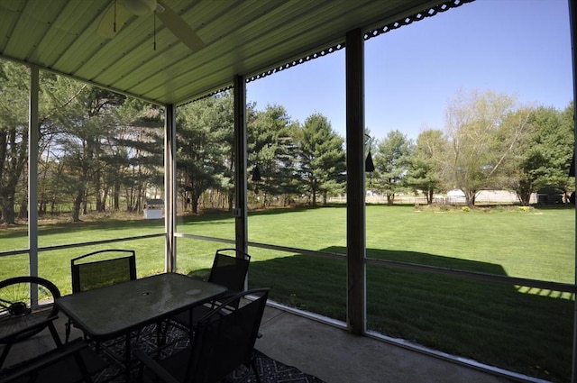 sunroom with a ceiling fan and outdoor dining area